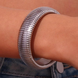 Close-up of a silver 20mm wide ribbed snake chain bangle in a minimalist industrial style