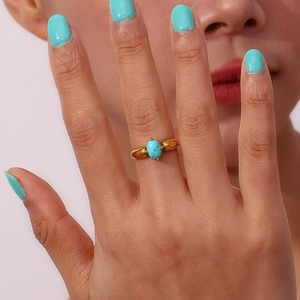 Detailaufnahme des 18K vergoldeten Rings mit ovalem Türkisstein an der Hand getragen