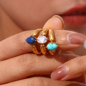 Makroaufnahme von vergoldeten Ringen mit Lapis, Zirkon und Türkis-Steinen