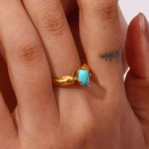 Nahaufnahme des 18K vergoldeten Blütenrings mit ovalem blauem Türkis am Finger getragen