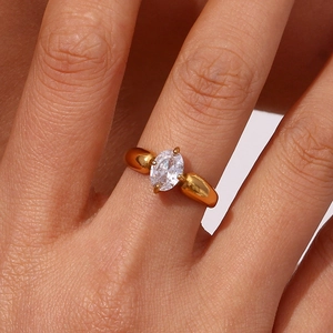 Detail eines 18K vergoldeten Rings mit ovalem Kristall und breiter, polierter Ringschiene