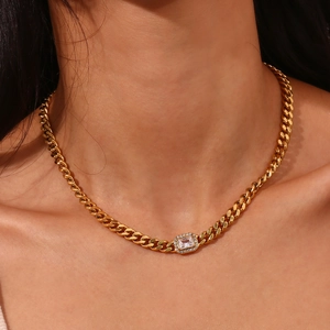 Close-up of gold Cuban link necklace with rectangular zircon pendant on a model neck
