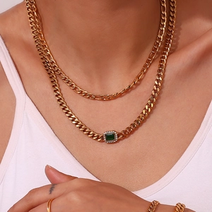 Detail of gold layered chain necklace with a rectangular emerald green zircon pendant