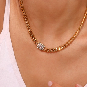 Close-up of gold cuban chain necklace featuring a rectangular zircon pendant on a model