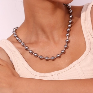 Détail du collier à billes argentées en acier inoxydable porté par le mannequin