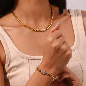 Detail of gold Cuban link necklace and bracelet set with rectangular zircon centerstones