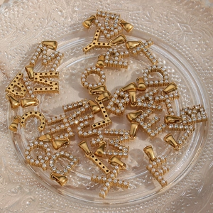 Makroansicht von 18K vergoldeten Edelstahlbuchstaben mit Perlen und Kristallen