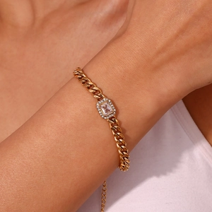 Close-up of golden Cuban link bracelet with a rectangle zircon center on woman wrist