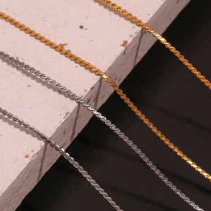 Detail von Gold- und Silber-Edelstahl-Kordelketten auf Naturstein-Display