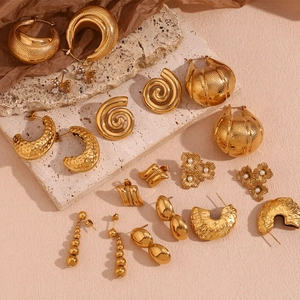 Detalle de pendientes de cacahuete chapados en oro 18K y cuentas sobre piedra