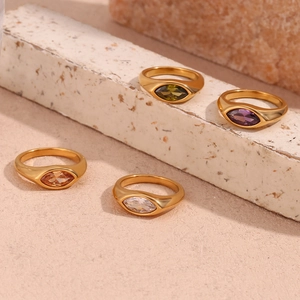 Detail of four gold rings with marquise-cut zircons in olive, purple, and champagne colors