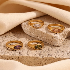 Detailed close-up of four 18K gold plated marquise zircon signet rings on silk