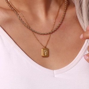 Detail showing gold layered necklace set with a rectangular lily flower pendant for women