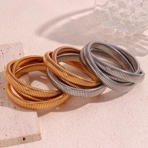 Dettaglio dei bracciali flessibili in acciaio inossidabile placcato oro 18K a tre toni