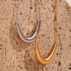 Detailed macro view of 18K gold and silver V-shaped pendants on sleek snake chains