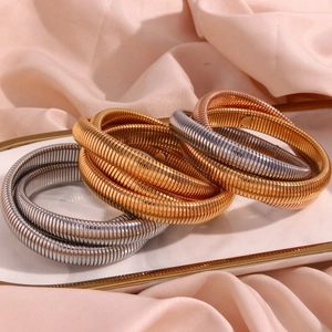 Dettaglio di bracciali flessibili a tre strati in oro, argento e oro rosa lucido