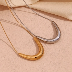 Detailed close-up of minimal V-shaped gold and silver pendants on sleek snake chains