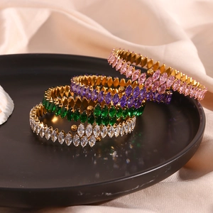 Close-up of luxury gold-plated bangles featuring marquise-cut zircons in various colors