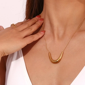 Detail of 18K gold-plated V-shaped pendant necklace on snake chain with metallic sheen