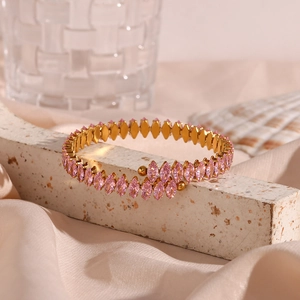 Detailed macro view of gold-plated bangle featuring marquise-cut pink cubic zirconia stones