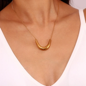 Close-up of elegant gold V-shaped pendant necklace worn on neck with sleek snake chain