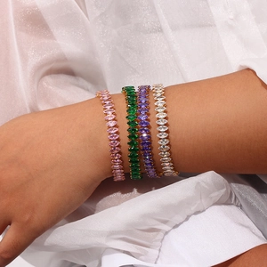 Detail showing gold bracelets with marquise-cut pink, green, purple and white zircons