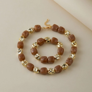 Dettaglio set di gioielli vintage fatti a mano con perle acriliche e sfere metalliche oro