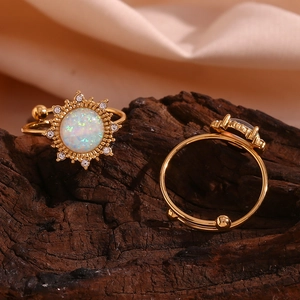 Detailansicht eines 18K vergoldeten Opalrings mit Sonnenstrahlen-Design auf Holz
