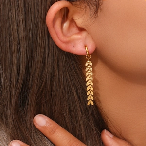 Detail of 18K gold-plated long leaf chain drop earrings worn by a female model