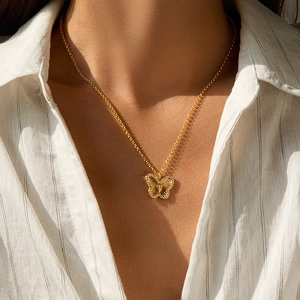 Close-up of 18K gold plated butterfly pendant necklace with sparkling zircon pavé on model