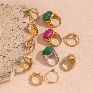 Macro view of vintage style 18K gold-plated rings with emerald and wave texture details