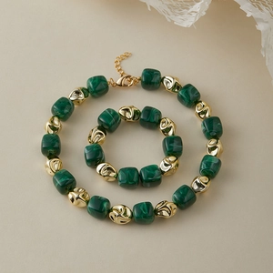Dettaglio ravvicinato di perle verdi trama malachite con distanziali in metallo dorato martellato