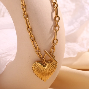 Detailed macro view of gold-plated OT buckle necklace with a striped heart pendant