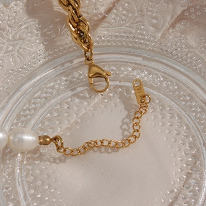 Macro detail of gold lobster clasp and adjustable chain with K18 stamp on pearl necklace