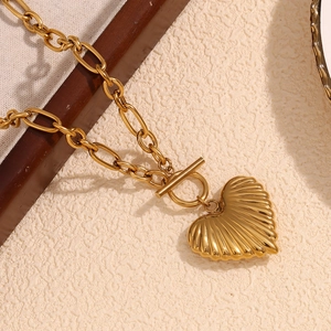 Detail view of 18K gold plated stainless steel heart pendant with textured finish and OT clasp