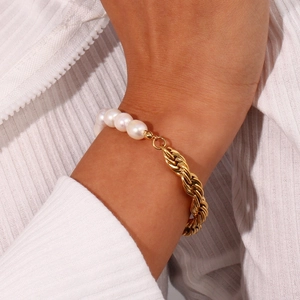 Detailed shot of a gold rope chain bracelet with natural white pearls on a wrist