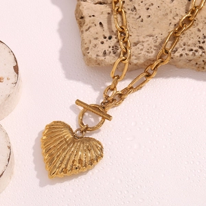 Macro shot of 18K gold plated heart pendant with toggle clasp and textured metal surface