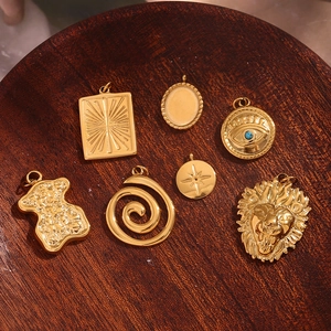 Detailed macro view of seven vintage 18K gold plated stainless steel pendants and charms