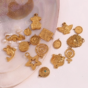 Detail of 18K gold-plated stainless steel pendants with starfish and vintage textures