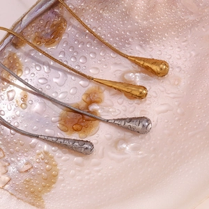 Détail macro de colliers goutte d'eau à texture martelée sur un coquillage avec des gouttes