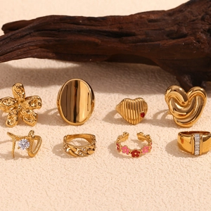 8-piece set of gold-plated rings including heart, snake and floral designs on a beige texture