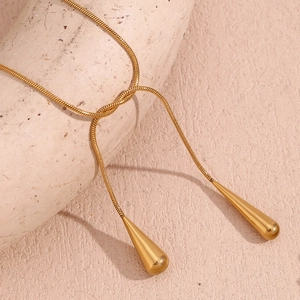 Vue détaillée du collier chaîne serpent doré avec deux pendentifs goutte d'eau élégants