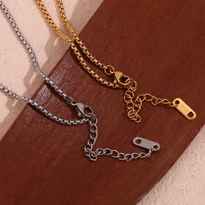 Detalle macro de cadenas box en oro de 18K y plata con cierres y etiquetas K18