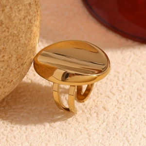 Detailed close-up of 18K gold-plated oval mirror ring on artistic stone base pedestal