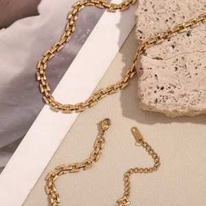 Macro detail of 18K gold plated rectangular chain links with lobster clasp and hallmark