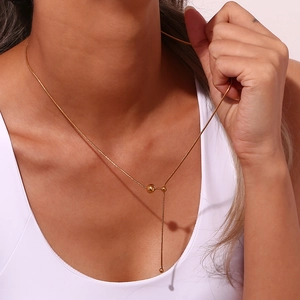Detalle macro de collar en Y con cadena de serpiente en acero inoxidable chapado en oro 18K