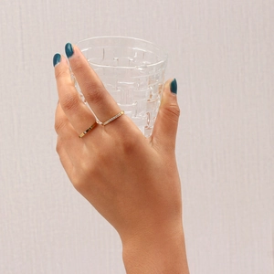 Detail of 18K gold plated stainless steel rings set with zircon stones on a female hand