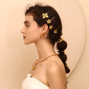 Close-up of elegant gold water drop hair tie and matching jewelry set on a model