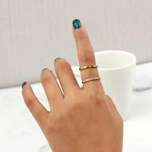 Close-up of gold plated rings with cubic zirconia inlay on elegant marble background