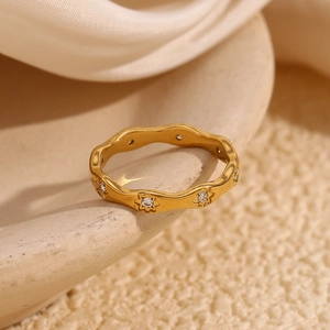Detail of 18K gold plated wavy ring featuring sparkling starburst set round zircons